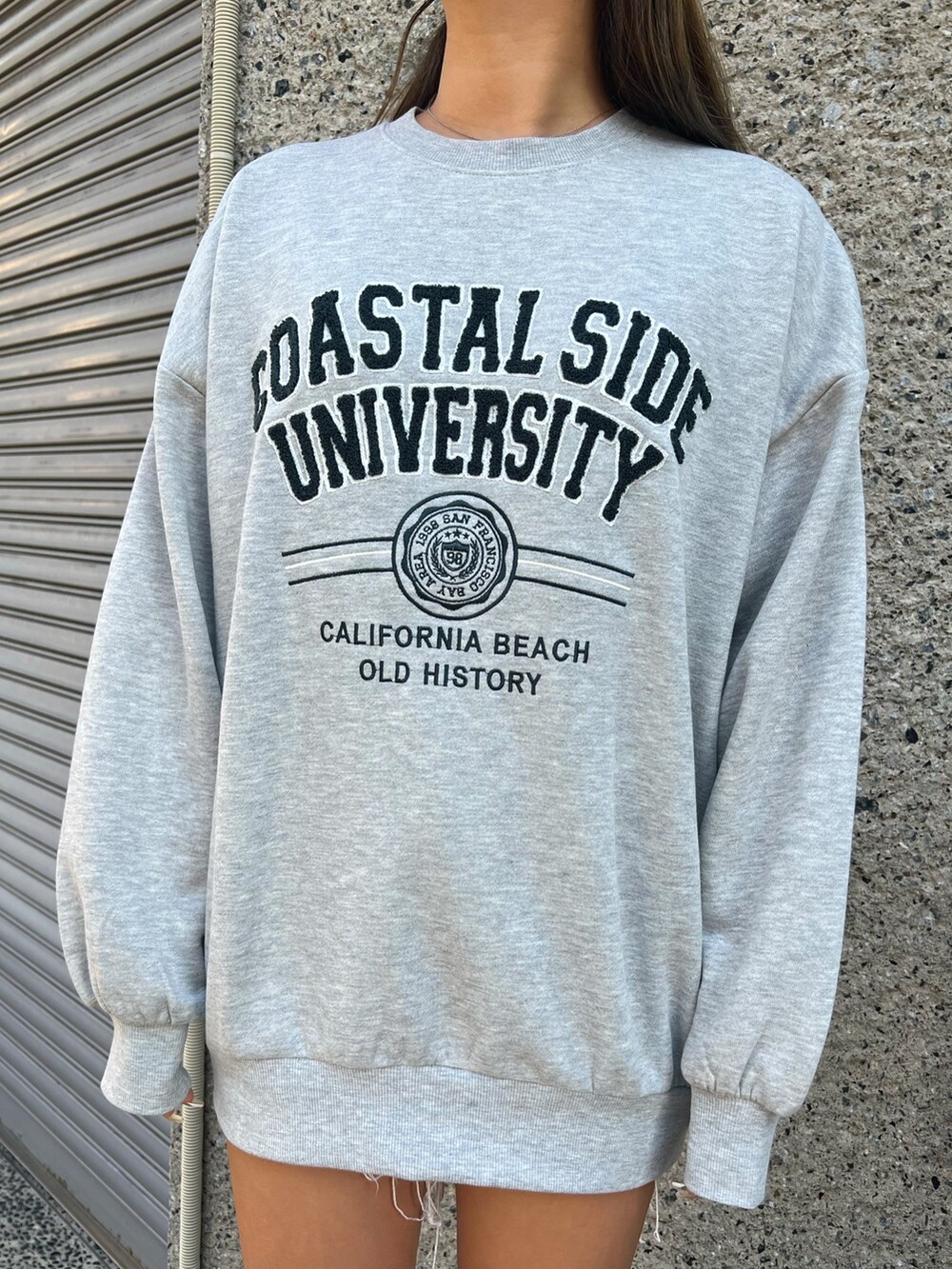 ブルー系のダウンジャケット/コート、グレー系のスウェット、ブラック系のショルダーバッグを着用したレディースの冬コーディネートの4枚目の写真