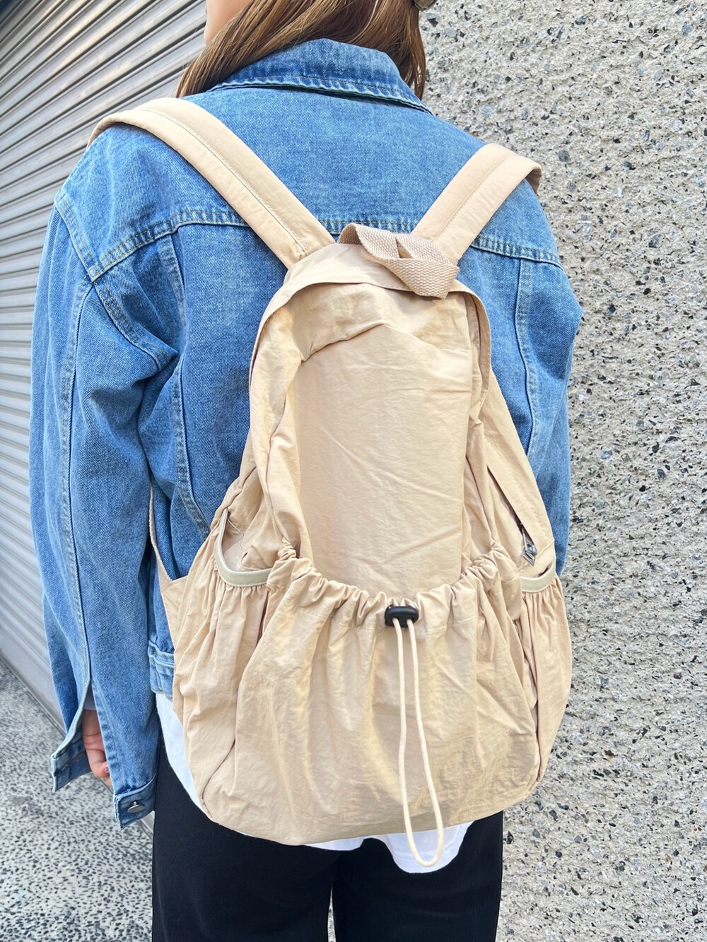 ベージュ系のバックパック/リュック、ブラック系のその他パンツ、レッド系のスニーカーを着用したレディースの冬コーディネートの7枚目の写真