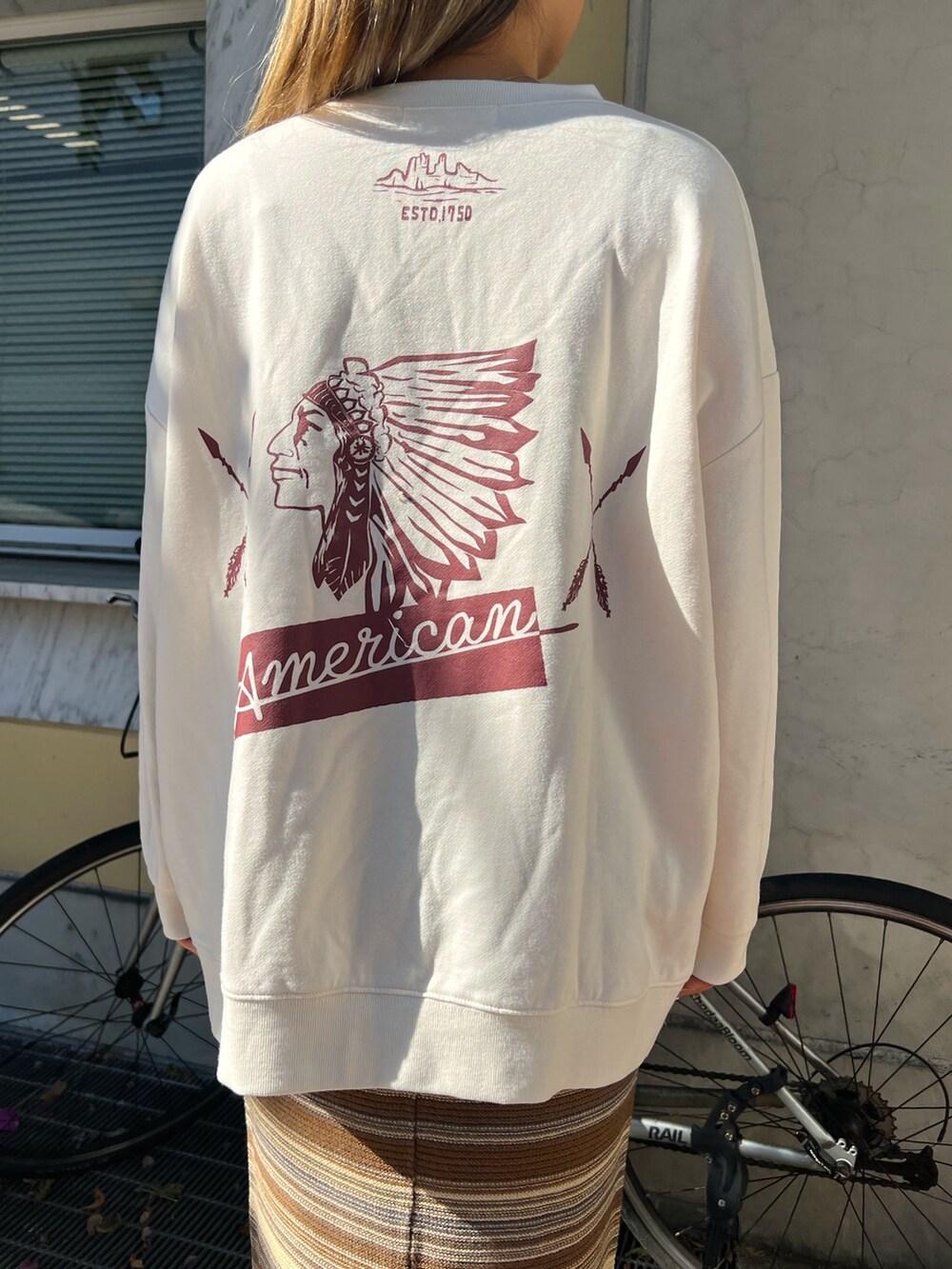 イエロー系のブーツ、ブラウン系のスカート、ベージュ系のスウェットを着用したレディースの冬コーディネートの5枚目の写真