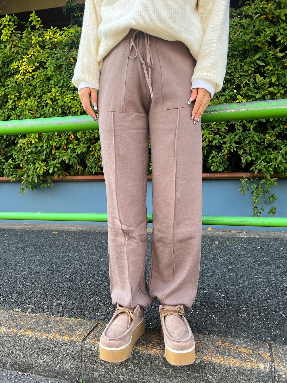 ホワイト系のショルダーバッグ、ホワイト系のニット/セーター、ベージュ系のその他パンツを着用したレディースの冬コーディネートの4枚目の写真