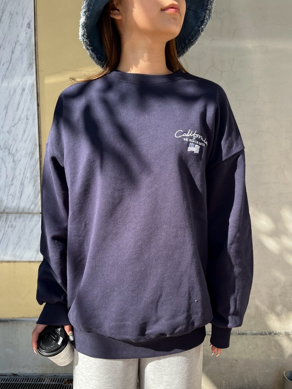 ブルー系のスウェット、グレー系のスウェットパンツ、ブラック系のスニーカーを着用したレディースの冬コーディネートの3枚目の写真