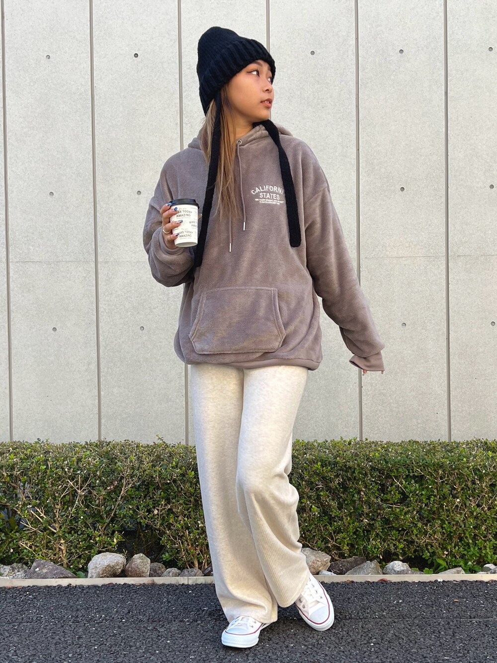 ブラウン系のパーカー、ホワイト系のその他パンツ、ホワイト系のスニーカーを着用したレディースの冬コーディネートの2枚目の写真