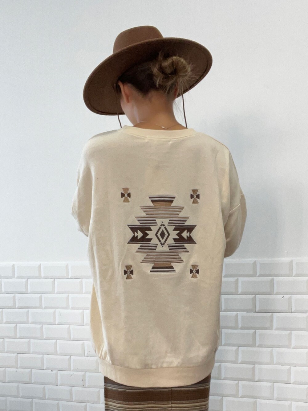 ブラウン系のスカート、ベージュ系のスウェット、ブラウン系のハットを着用したレディースの秋コーディネートの3枚目の写真