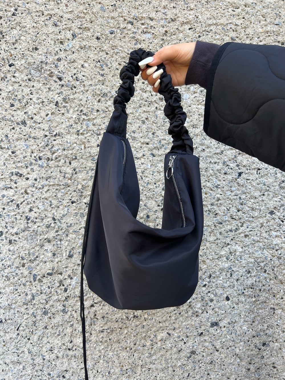 ブルー系のデニムパンツ、グレー系のスウェット、ブラック系のショルダーバッグを着用したレディースの冬コーディネートの4枚目の写真