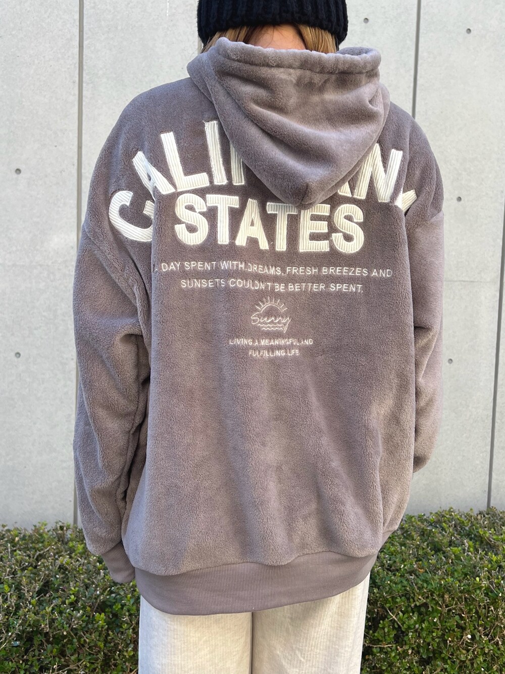 ブラウン系のパーカー、ホワイト系のその他パンツ、ホワイト系のスニーカーを着用したレディースの冬コーディネートの4枚目の写真