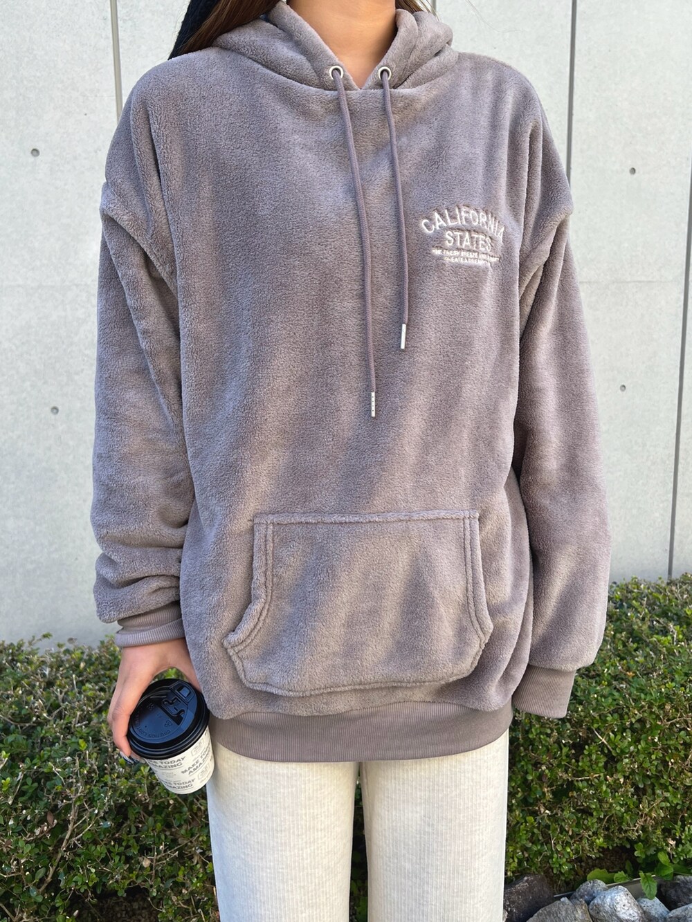 ブラウン系のパーカー、ホワイト系のその他パンツ、ホワイト系のスニーカーを着用したレディースの冬コーディネートの3枚目の写真