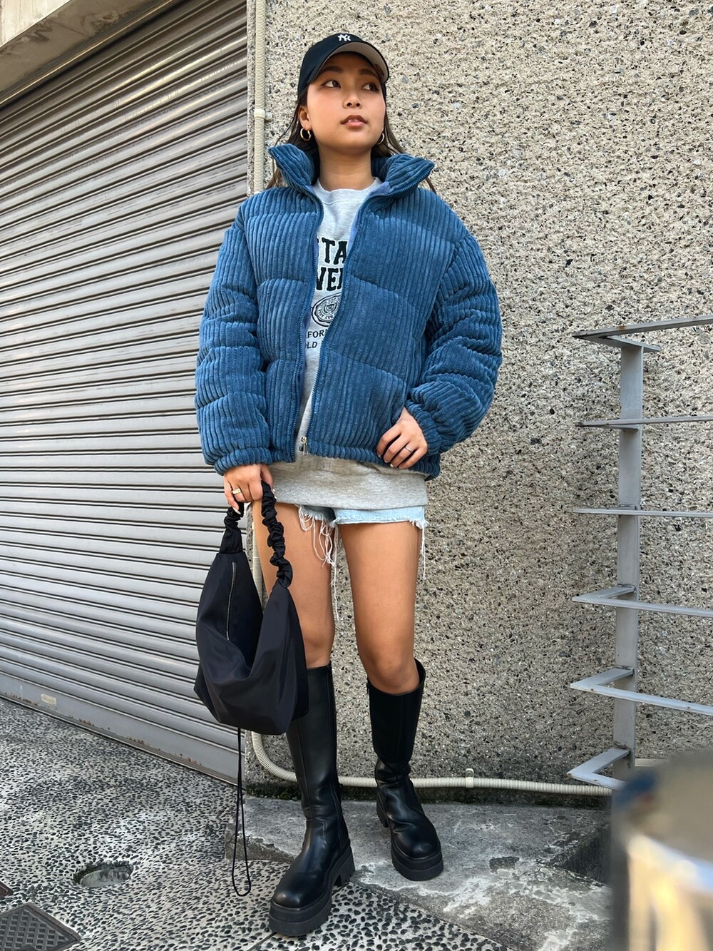 ブルー系のダウンジャケット/コート、グレー系のスウェット、ブラック系のショルダーバッグを着用したレディースの冬コーディネートの2枚目の写真