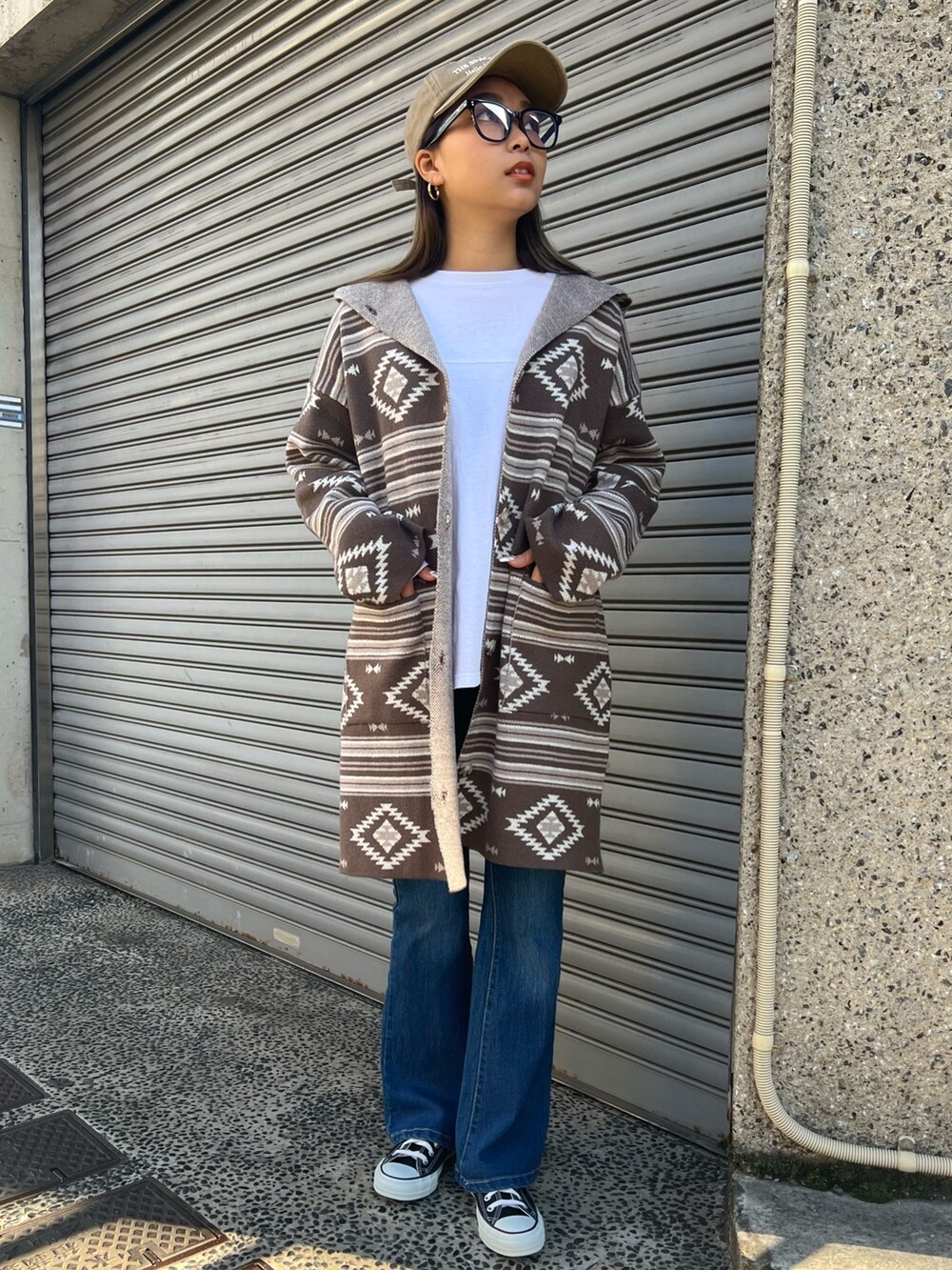 ブラック系のスニーカー、ブルー系のデニムパンツ、ブラウン系のカーディガン/ボレロを着用したレディースの冬コーディネートの2枚目の写真