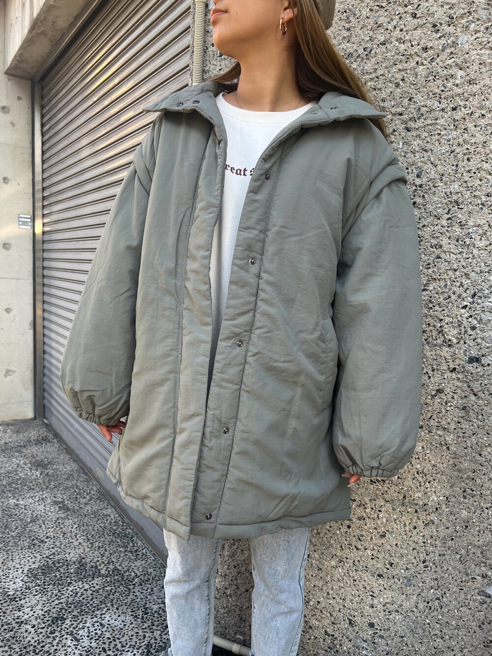 ブルー系のデニムパンツ、グリーン系のダウンジャケット/コート、ベージュ系のスウェットを着用したレディースの冬コーディネートの4枚目の写真