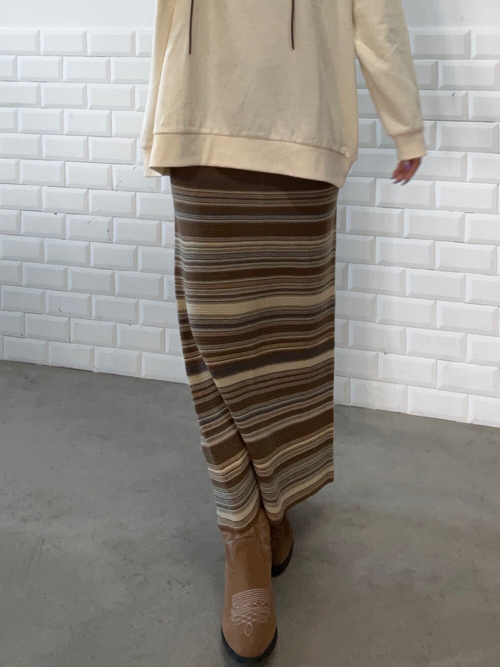 ブラウン系のスカート、ベージュ系のスウェット、ブラウン系のハットを着用したレディースの秋コーディネートの4枚目の写真