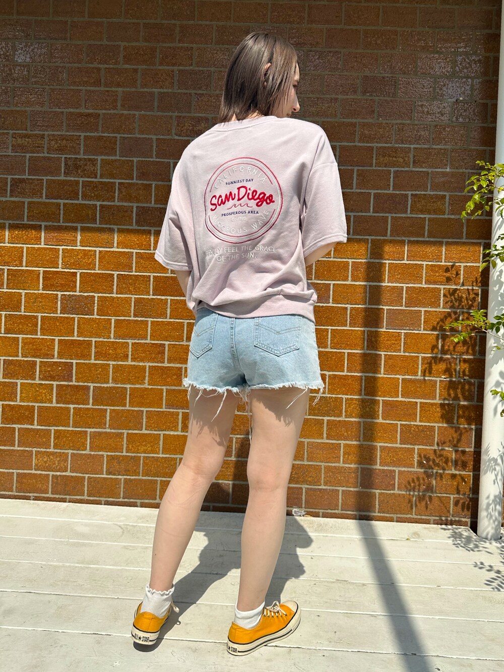 ピンク系のTシャツ/カットソー、イエロー系のスニーカーを着用したレディースの春コーディネートの2枚目の写真
