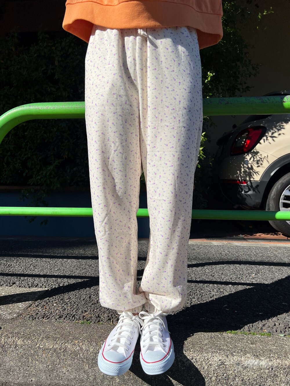 オレンジ系のスウェット、ホワイト系のスウェットパンツ、オレンジ系のバレッタ/ヘアクリップを着用したレディースの冬コーディネートの4枚目の写真