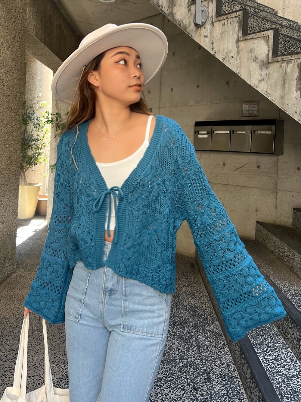 ブルー系のカーディガン/ボレロ、ベージュ系のスニーカー、ホワイト系のハットを着用したレディースの春コーディネートの3枚目の写真