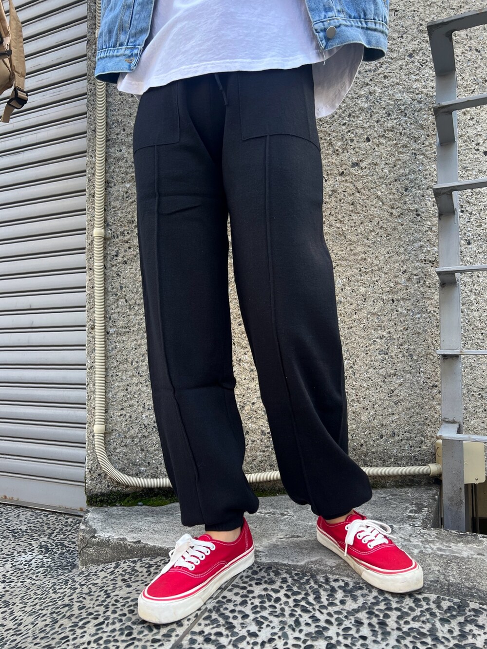 ベージュ系のバックパック/リュック、ブラック系のその他パンツ、レッド系のスニーカーを着用したレディースの冬コーディネートの5枚目の写真