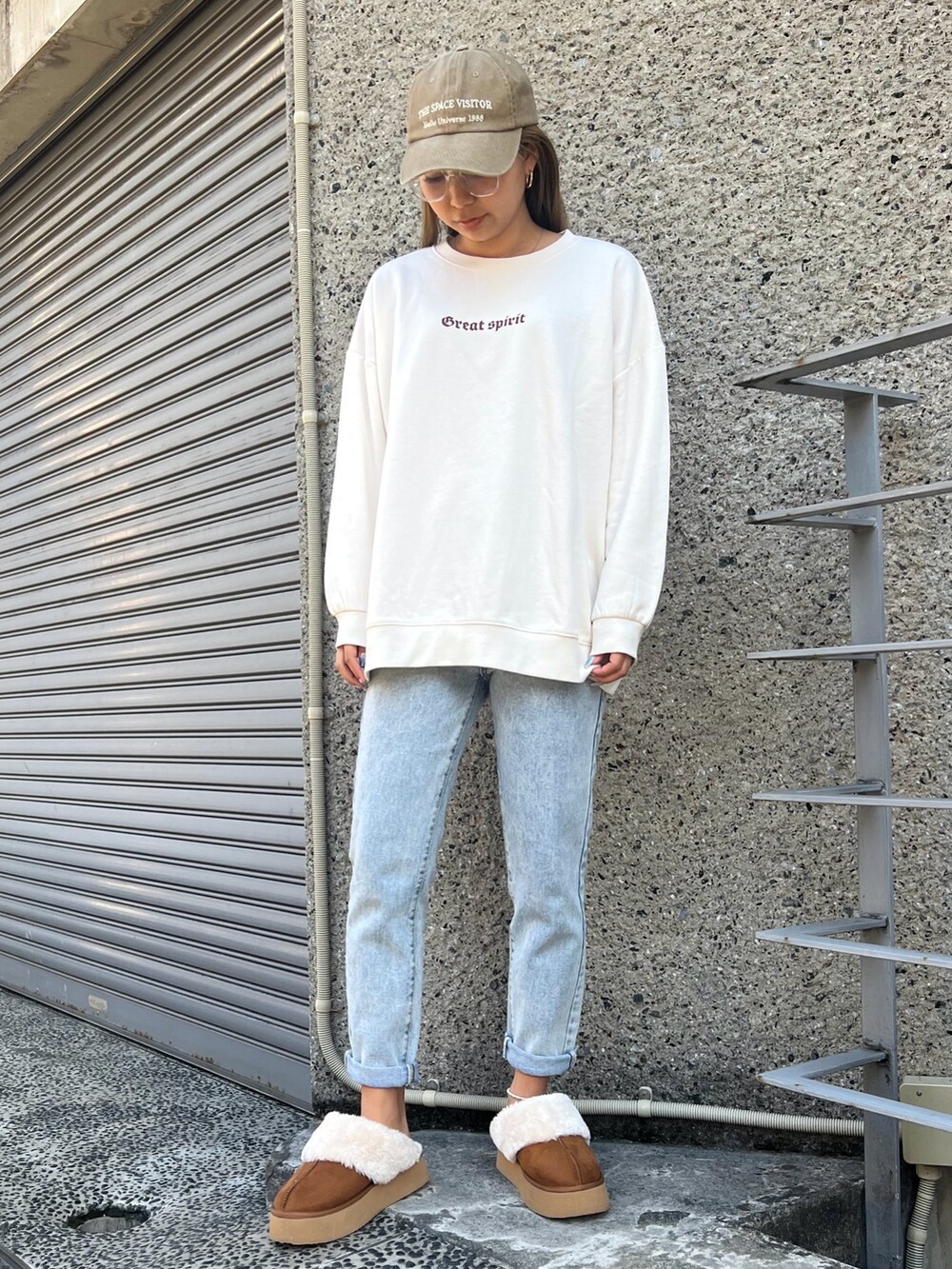 ブルー系のデニムパンツ、グリーン系のダウンジャケット/コート、ベージュ系のスウェットを着用したレディースの冬コーディネートの2枚目の写真