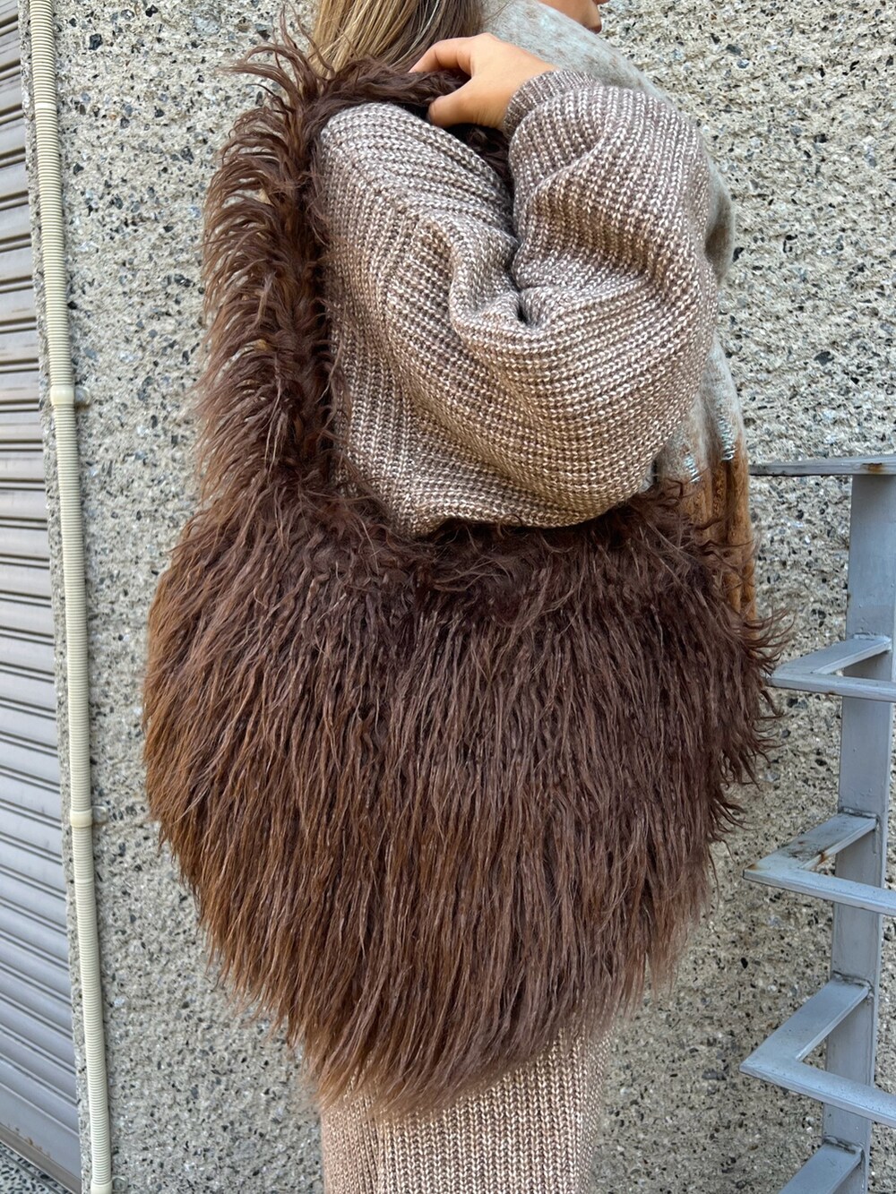 ブラウン系のショルダーバッグ、ベージュ系のスニーカー、ブラウン系のワンピースを着用したレディースの冬コーディネートの6枚目の写真