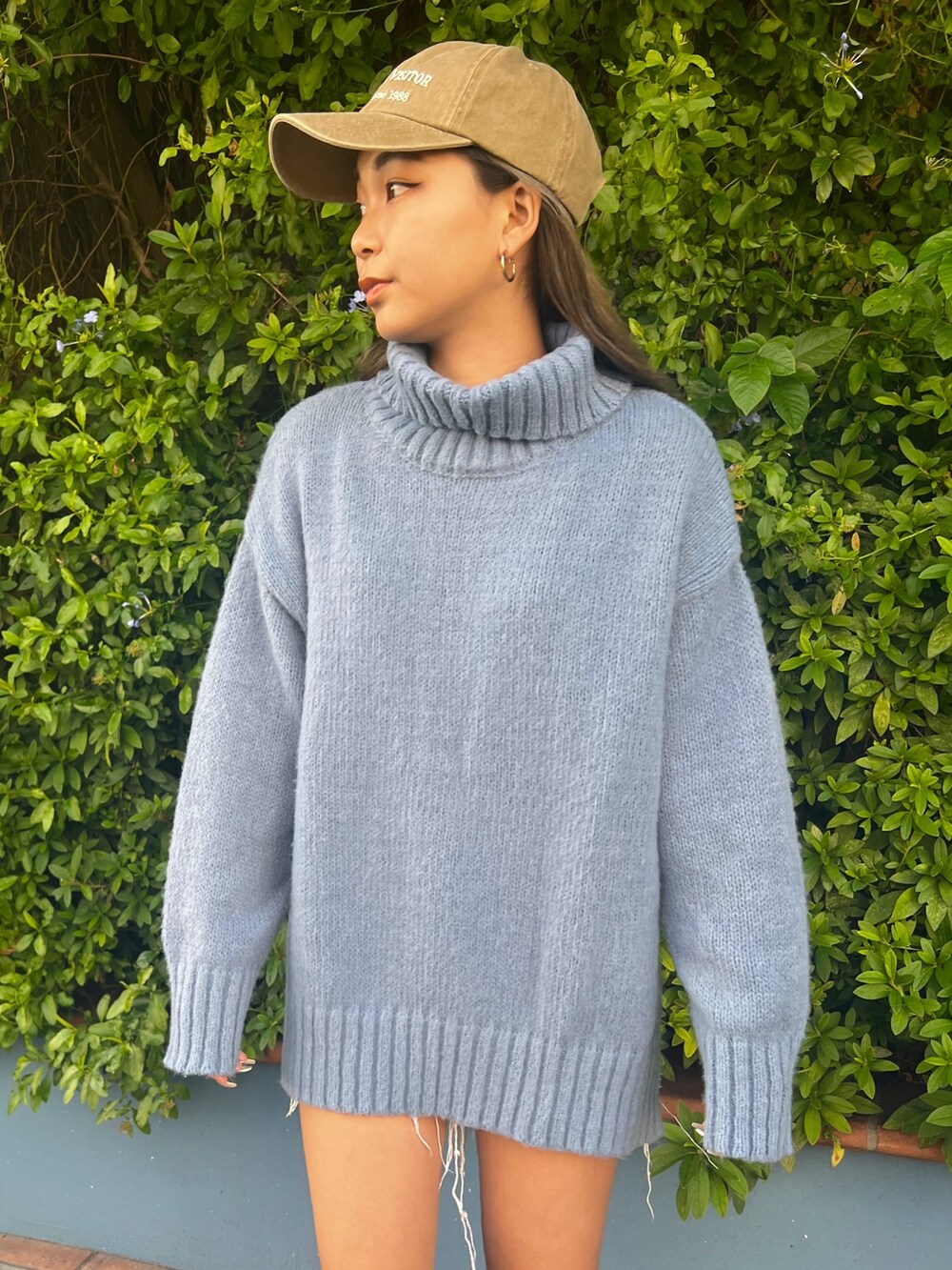 ブルー系のニット/セーター、ベージュ系のキャップを着用したレディースの冬コーディネートの2枚目の写真