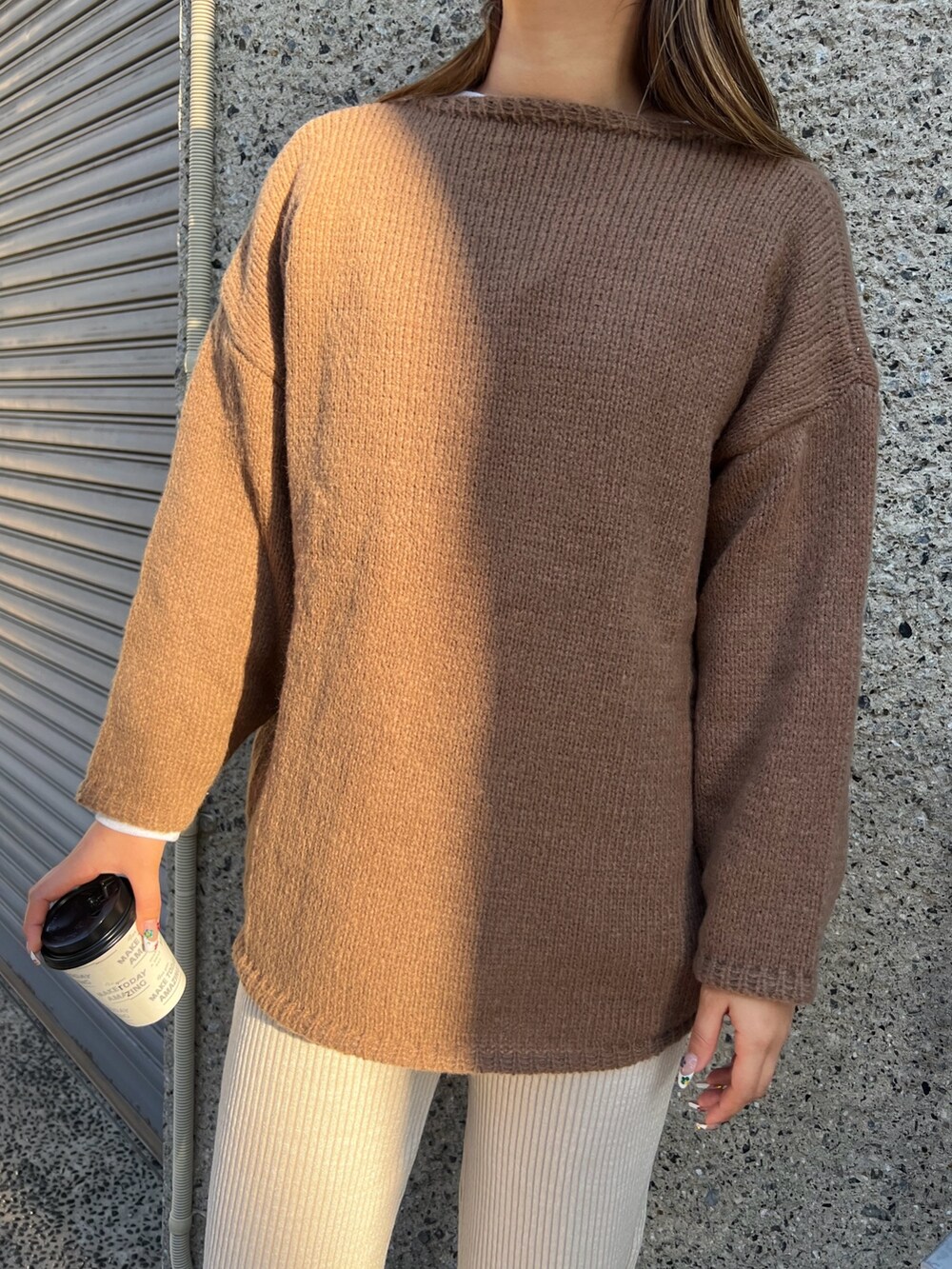 ブラウン系のニット/セーター、ベージュ系のその他パンツ、ブラック系のスニーカーを着用したレディースの冬コーディネートの3枚目の写真