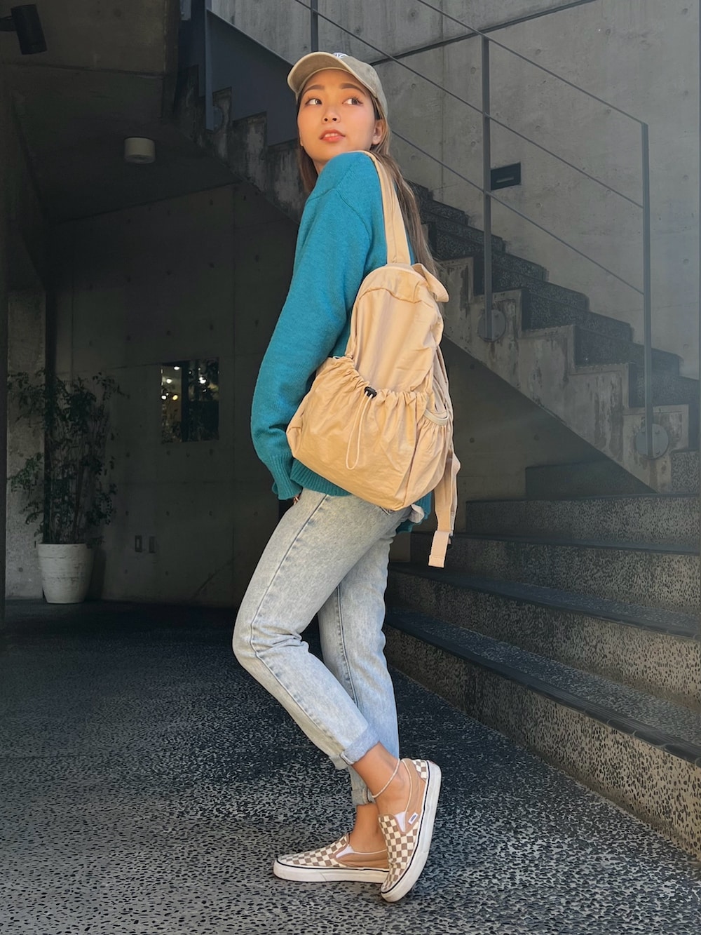 ブルー系のカーディガン/ボレロ、ベージュ系のバックパック/リュック、ベージュ系のスニーカーを着用したレディースの冬コーディネートの2枚目の写真