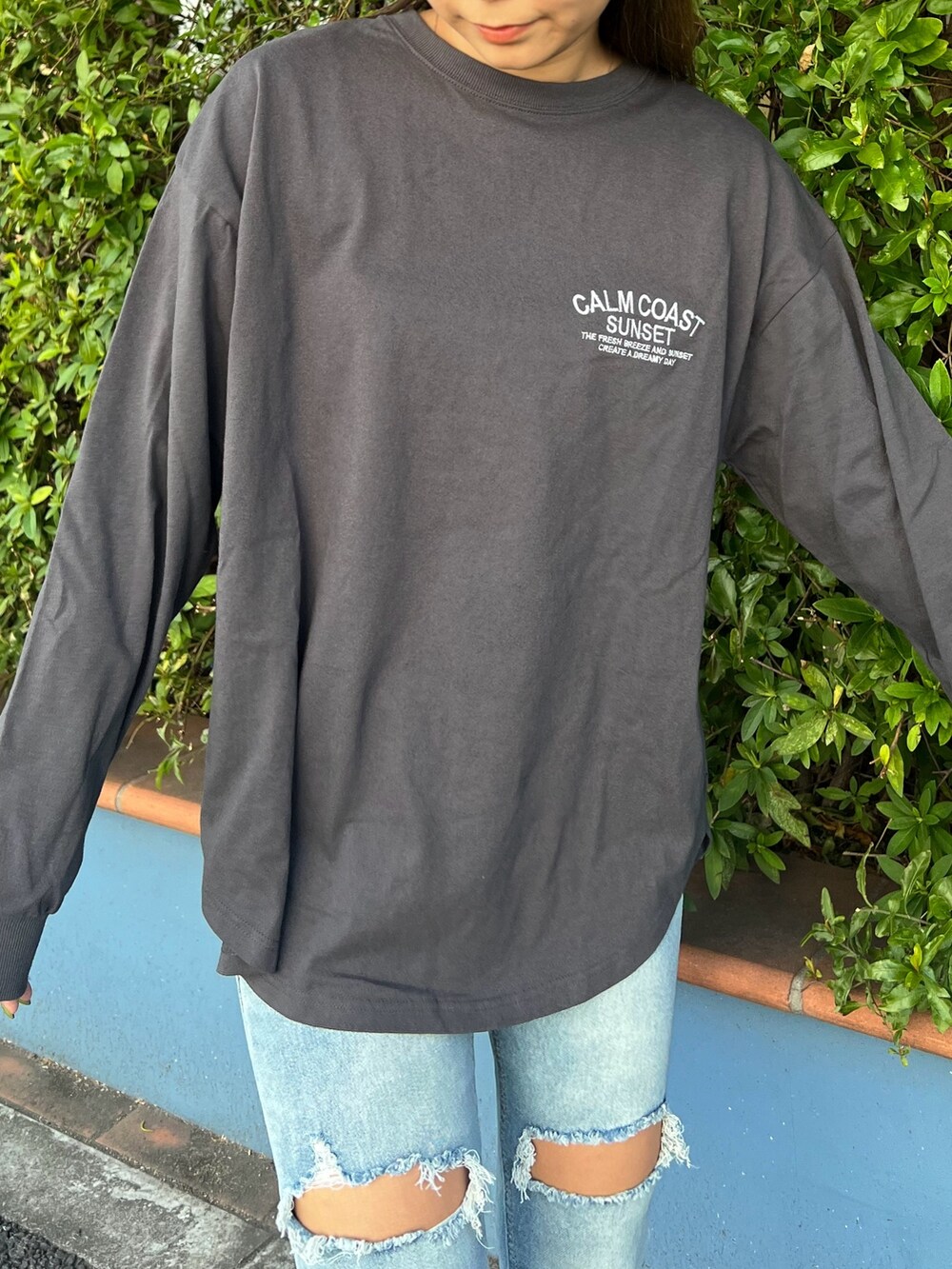 グレー系のTシャツ/カットソー、ブルー系のデニムパンツ、ベージュ系のスニーカーを着用したレディースの春コーディネートの4枚目の写真