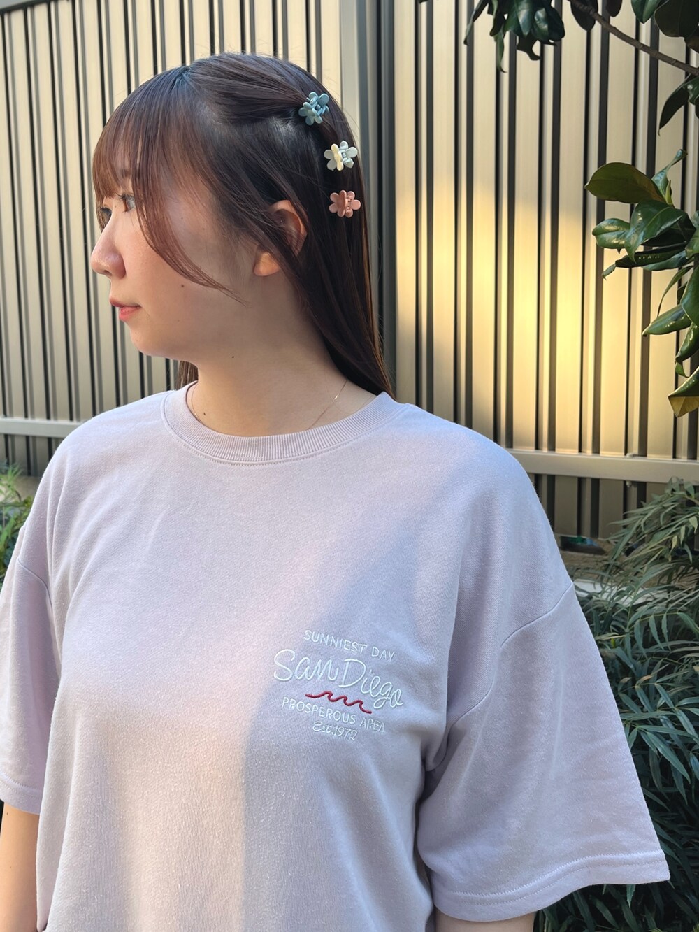 ピンク系のTシャツ/カットソー、ブルー系のデニムパンツ、オレンジ系のバレッタ/ヘアクリップを着用したレディースの春コーディネートの3枚目の写真