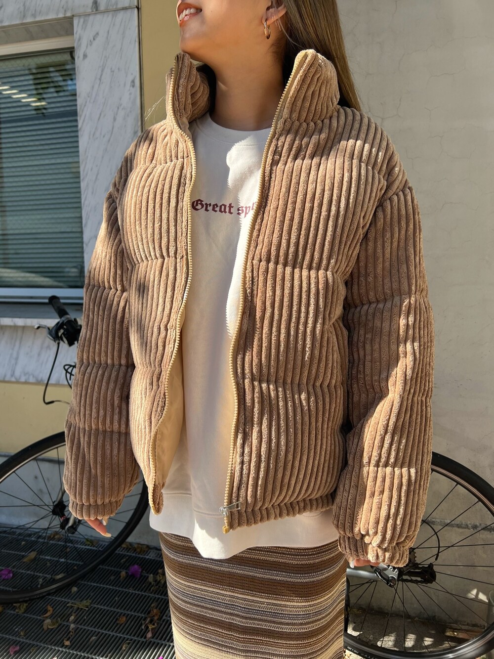 イエロー系のブーツ、ブラウン系のスカート、ベージュ系のスウェットを着用したレディースの冬コーディネートの3枚目の写真