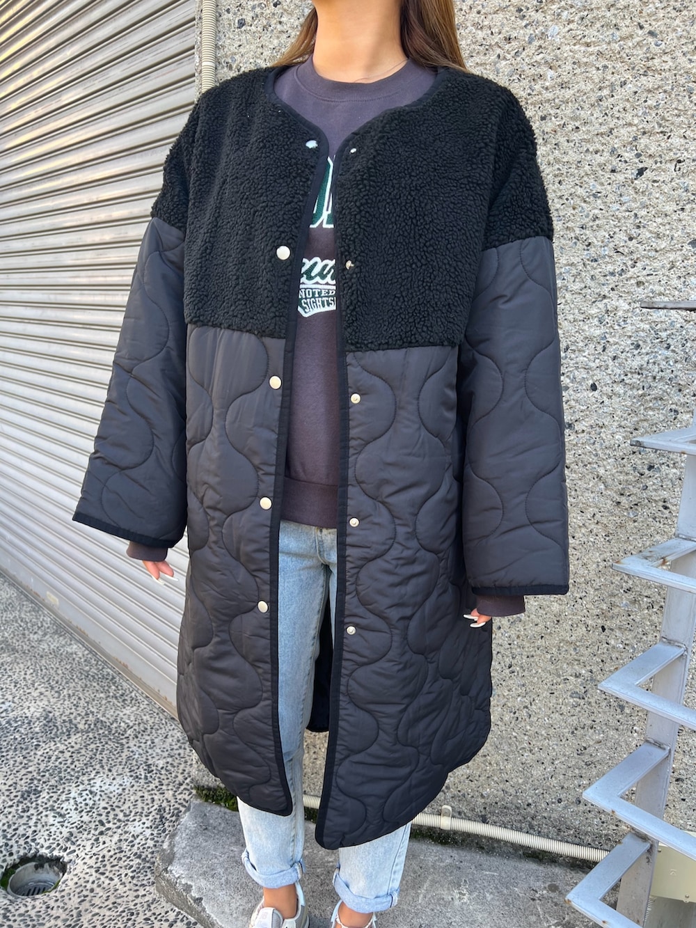 ブルー系のデニムパンツ、グレー系のスウェット、ブラック系のショルダーバッグを着用したレディースの冬コーディネートの2枚目の写真