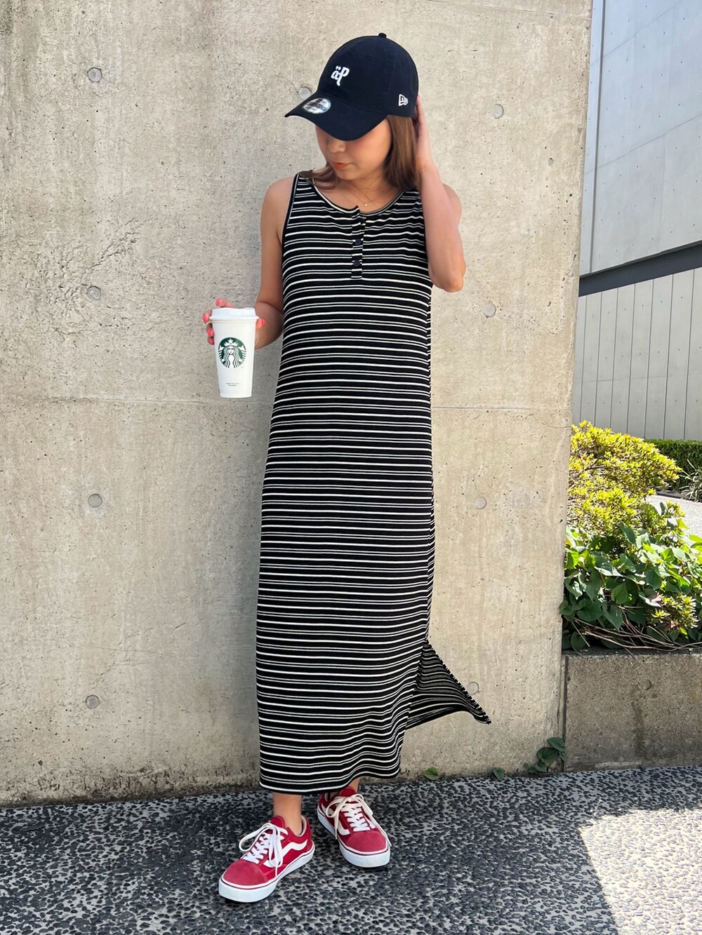 ブラック系のワンピース、ブルー系のデニムジャケット、レッド系のスニーカーを着用したレディースの春コーディネートの2枚目の写真