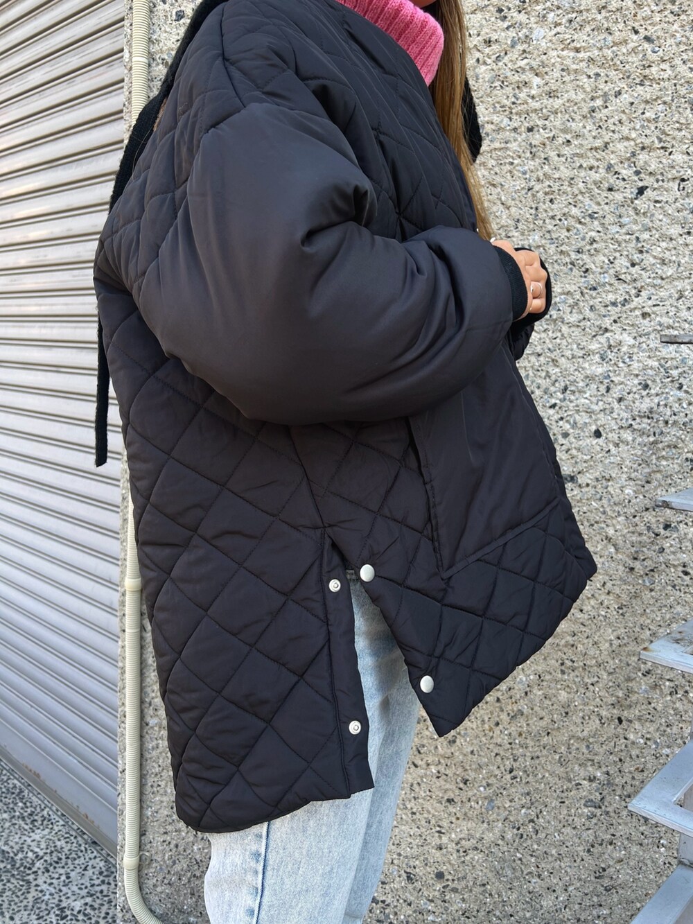 ブラック系のショルダーバッグ、ベージュ系のスニーカー、ブルー系のデニムパンツを着用したレディースの冬コーディネートの3枚目の写真