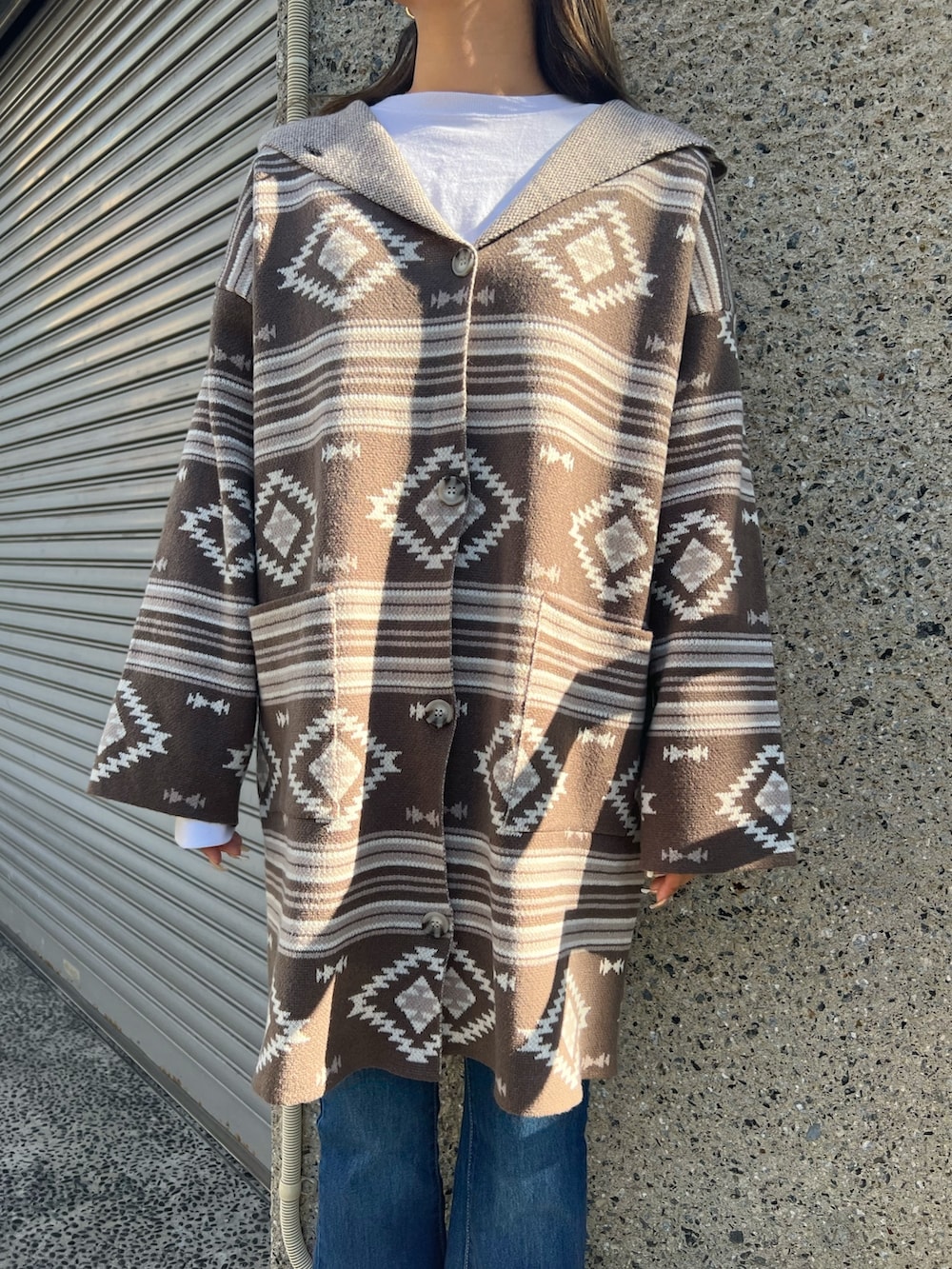 ブラック系のスニーカー、ブルー系のデニムパンツ、ブラウン系のカーディガン/ボレロを着用したレディースの冬コーディネートの3枚目の写真