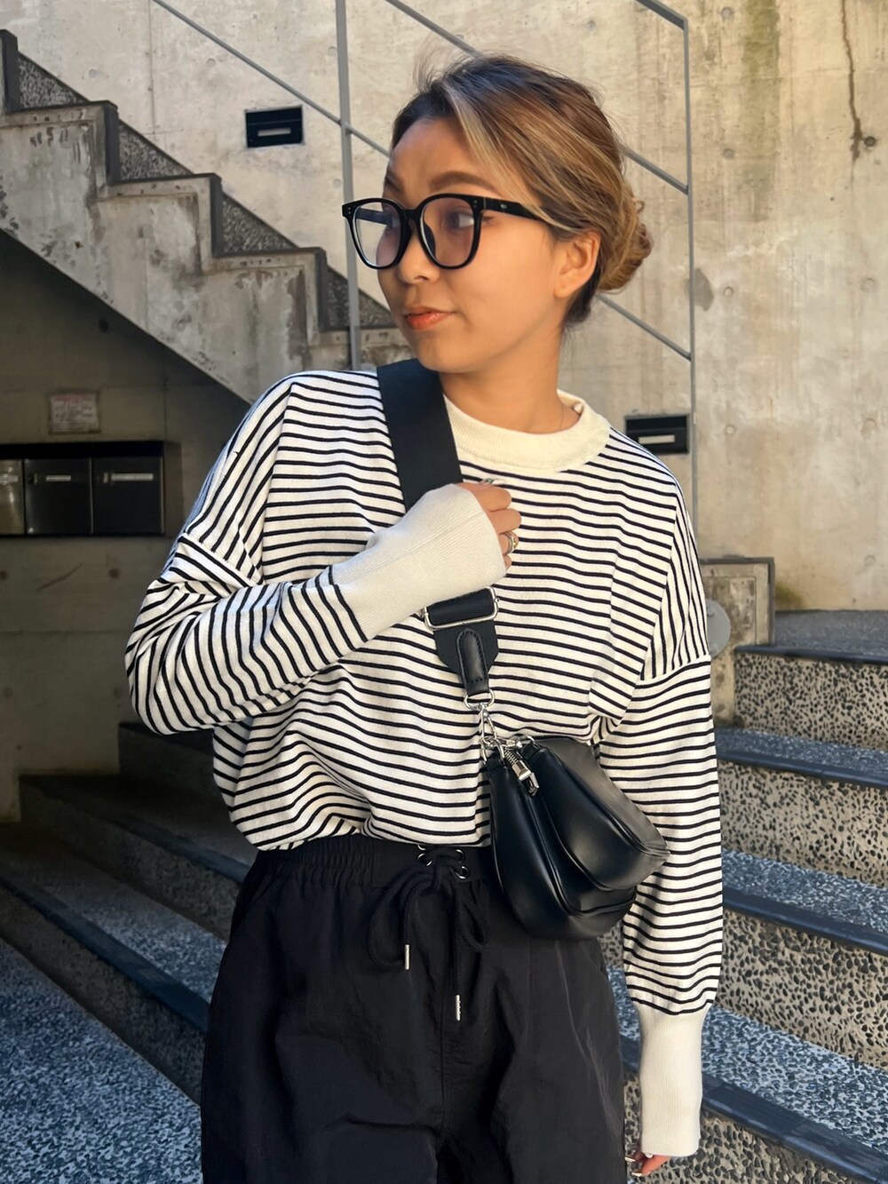 ブラック系のニット/セーター、ブラック系のショルダーバッグ、ブラック系のカーゴパンツを着用したレディースの春コーディネートの3枚目の写真