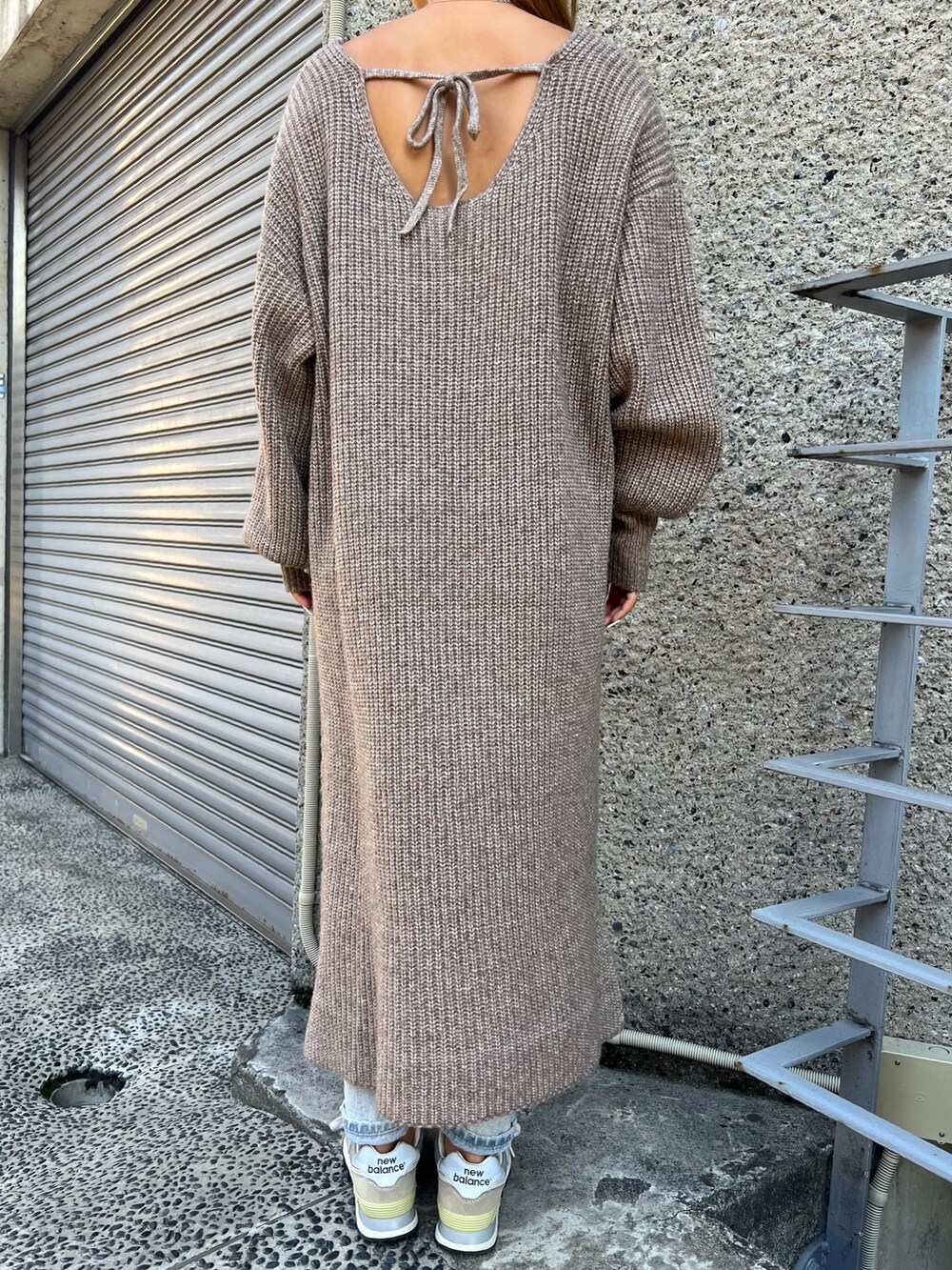 ブラウン系のショルダーバッグ、ベージュ系のスニーカー、ブラウン系のワンピースを着用したレディースの冬コーディネートの4枚目の写真