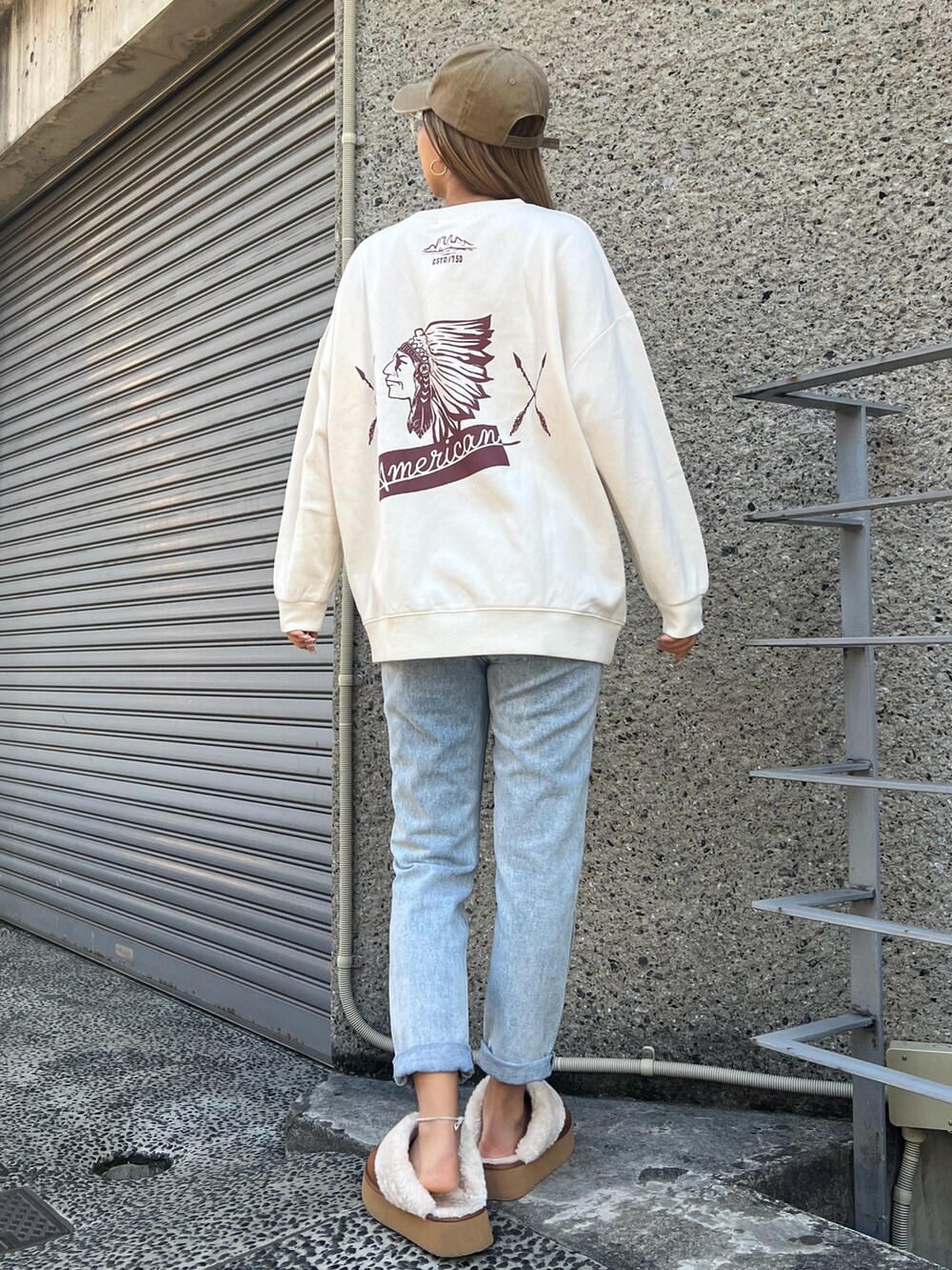 ブルー系のデニムパンツ、グリーン系のダウンジャケット/コート、ベージュ系のスウェットを着用したレディースの冬コーディネートの3枚目の写真