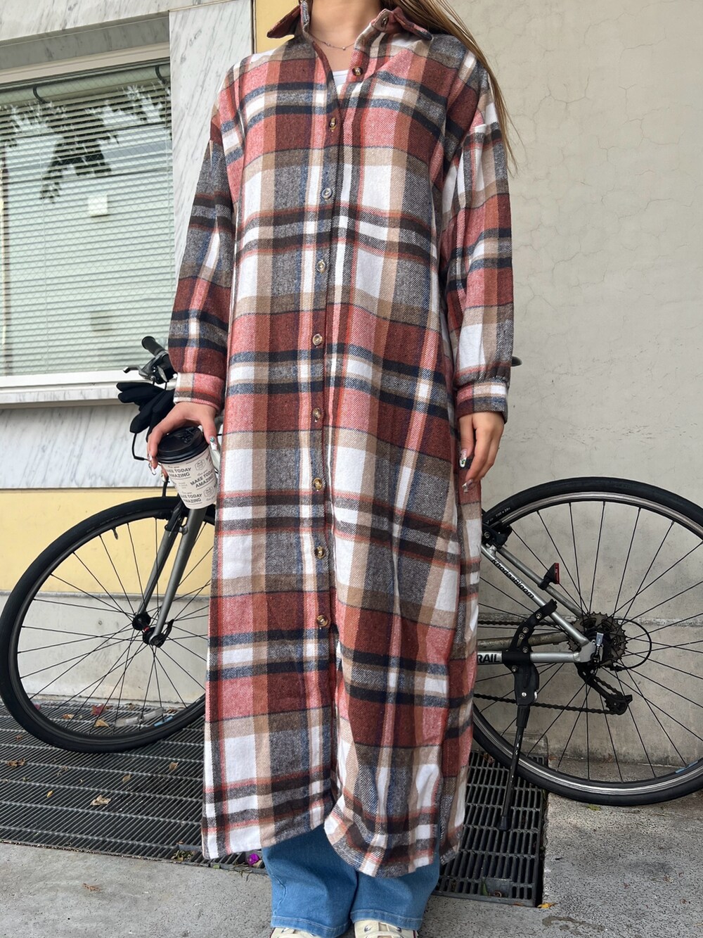 ベージュ系のショルダーバッグ、オレンジ系のワンピース、その他のスニーカーを着用したレディースの冬コーディネートの3枚目の写真