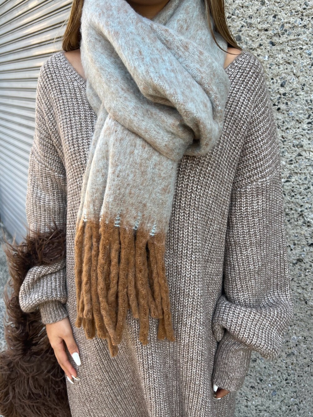 ブラウン系のショルダーバッグ、ベージュ系のスニーカー、ブラウン系のワンピースを着用したレディースの冬コーディネートの5枚目の写真