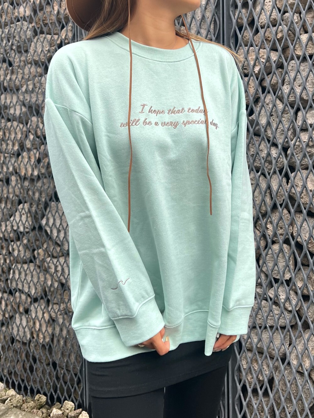 ホワイト系のブルゾン、グリーン系のスウェット、ベージュ系のスリッポンを着用したレディースの冬コーディネートの3枚目の写真