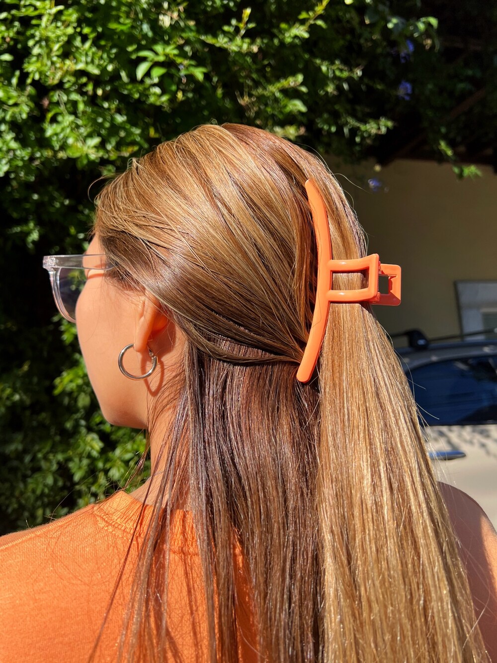 オレンジ系のスウェット、ホワイト系のスウェットパンツ、オレンジ系のバレッタ/ヘアクリップを着用したレディースの冬コーディネートの5枚目の写真