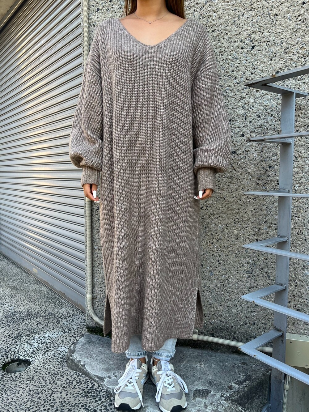 ブラウン系のショルダーバッグ、ベージュ系のスニーカー、ブラウン系のワンピースを着用したレディースの冬コーディネートの3枚目の写真