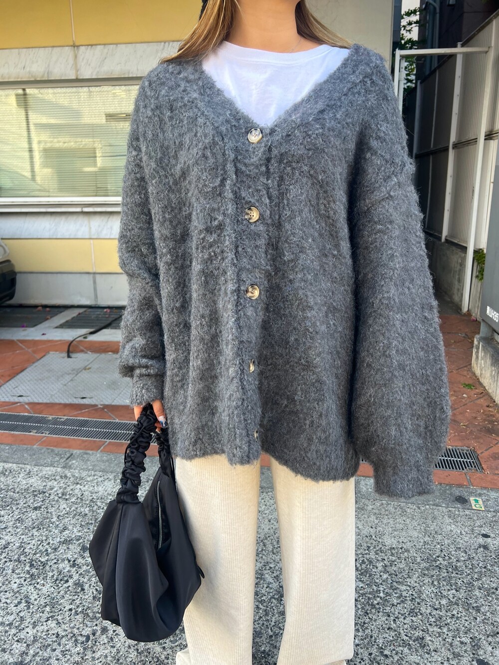 グレー系のカーディガン/ボレロ、ホワイト系のその他パンツ、グレー系のスリッポンを着用したレディースの冬コーディネートの3枚目の写真