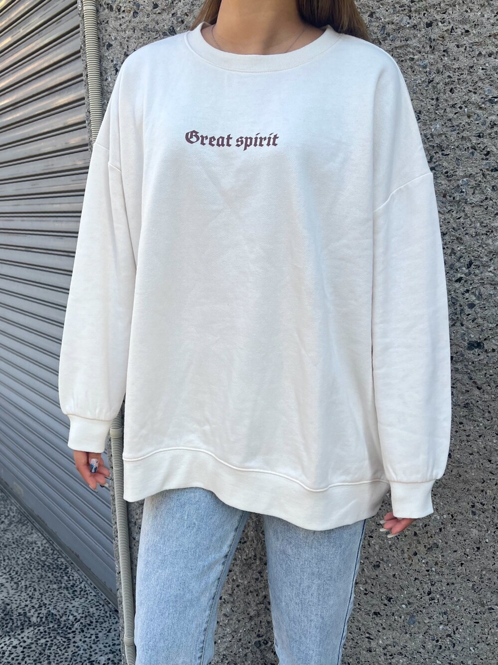 ブルー系のデニムパンツ、グリーン系のダウンジャケット/コート、ベージュ系のスウェットを着用したレディースの冬コーディネートの5枚目の写真