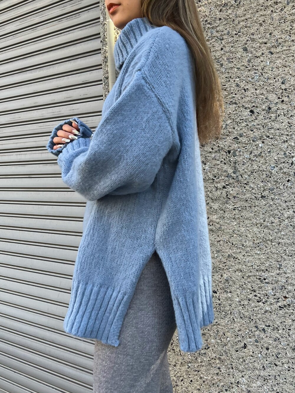 ブルー系のニット/セーター、ベージュ系のキャップを着用したレディースの冬コーディネートの5枚目の写真