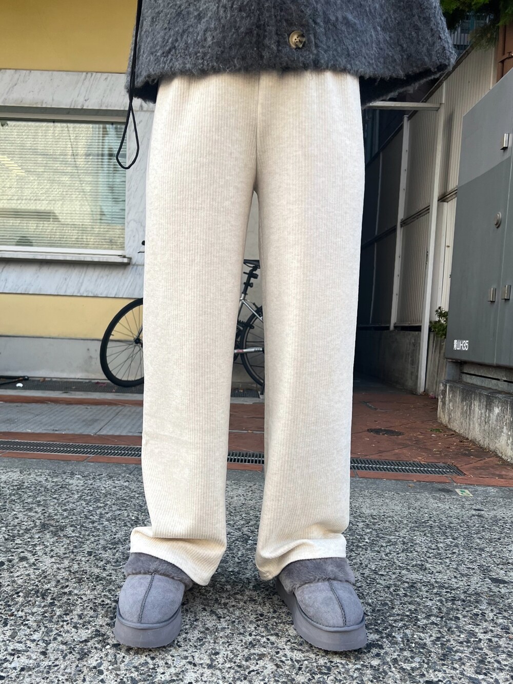 グレー系のカーディガン/ボレロ、ホワイト系のその他パンツ、グレー系のスリッポンを着用したレディースの冬コーディネートの4枚目の写真