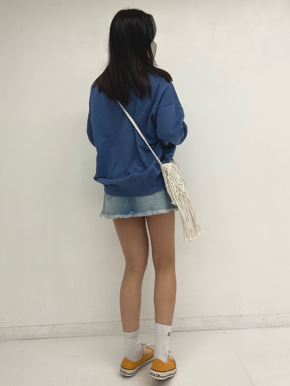 ブルー系のスウェット、ブルー系のデニムスカートを着用したレディースの春コーディネートの2枚目の写真