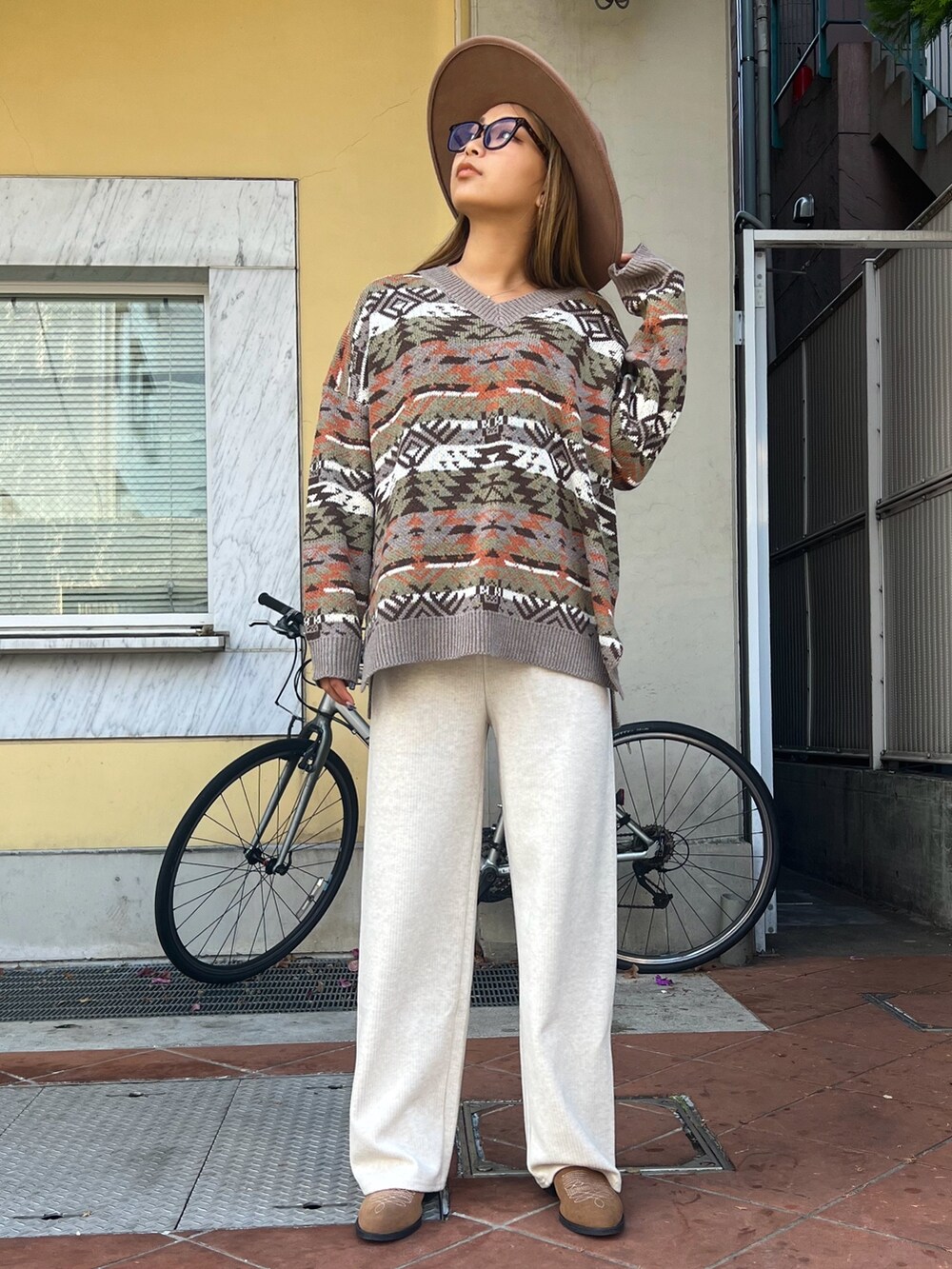 グリーン系のブルゾン、ベージュ系のニット/セーター、ホワイト系のその他パンツを着用したレディースの冬コーディネートの2枚目の写真