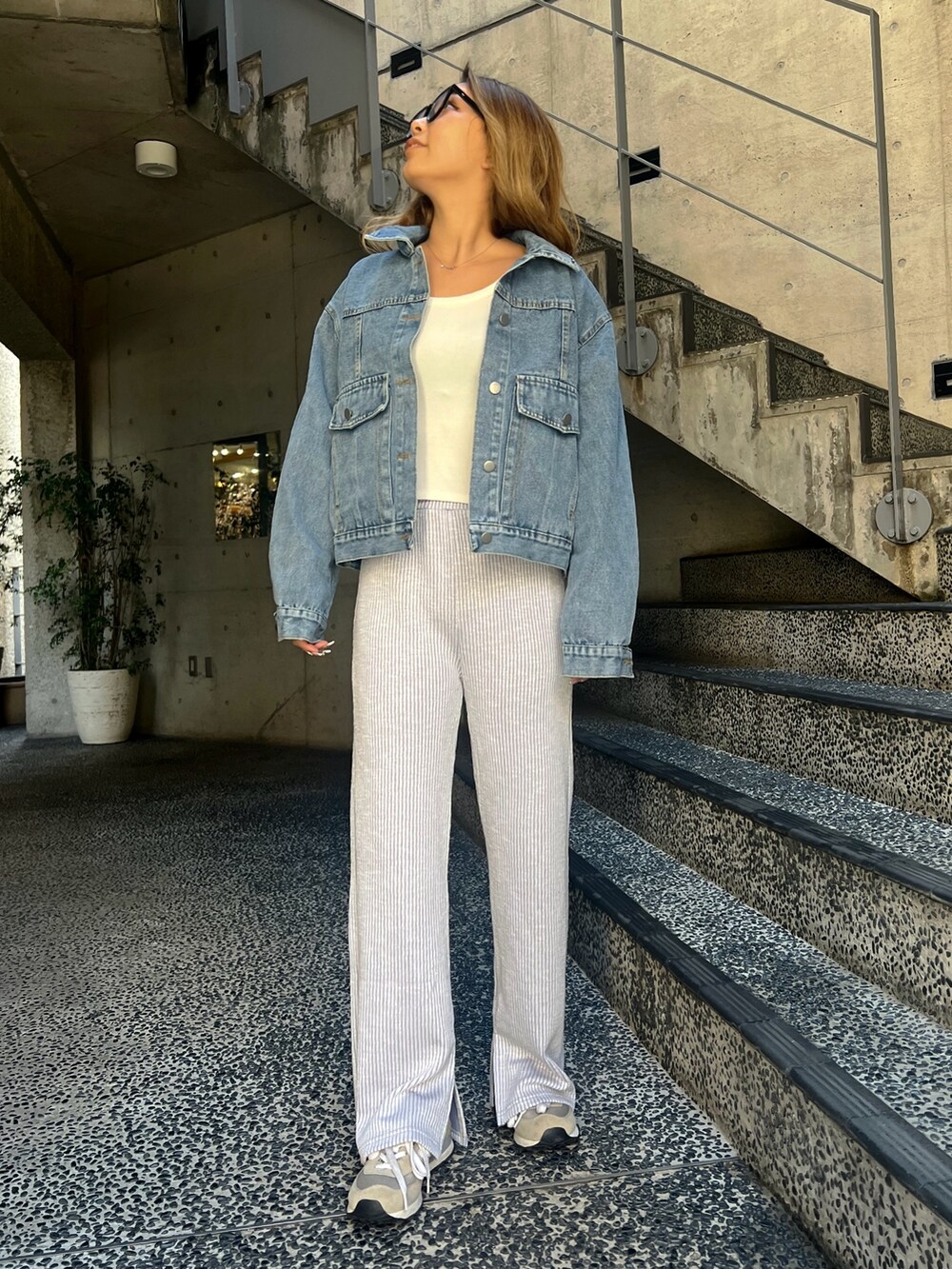 ブルー系のデニムジャケット、パープル系のその他パンツ、ベージュ系のスニーカーを着用したレディースの春コーディネートの2枚目の写真