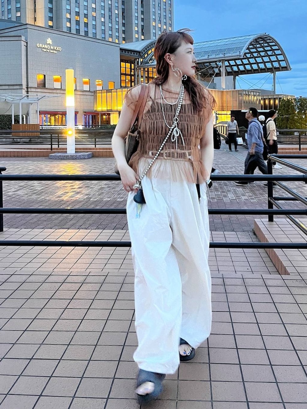 ブラック系のサンダル、グレー系のその他パンツ、シルバー系のスマホグッズを着用したレディースの夏コーディネートの3枚目の写真