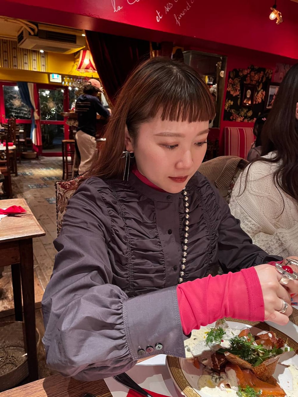 ブラック系のスラックス、グレー系のシャツ/ブラウス、シルバー系のスマホグッズを着用したレディースの冬コーディネートの2枚目の写真