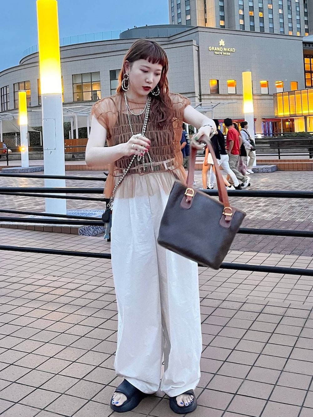 ブラック系のサンダル、グレー系のその他パンツ、シルバー系のスマホグッズを着用したレディースの夏コーディネートの2枚目の写真