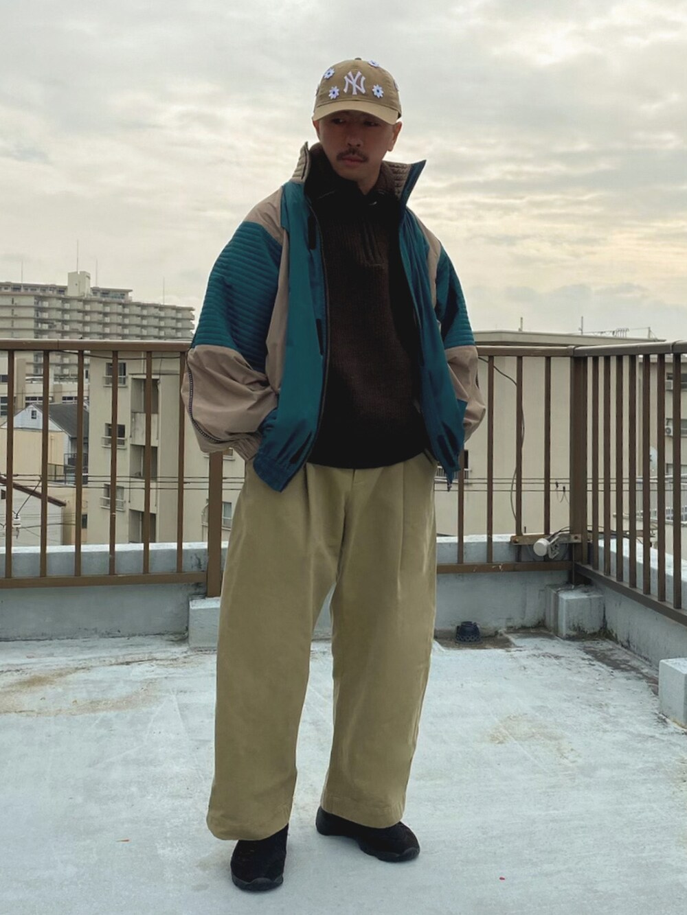 ベージュ系のブルゾン、グリーン系のその他パンツ、ブラック系のスニーカーを着用したメンズの冬コーディネートの3枚目の写真