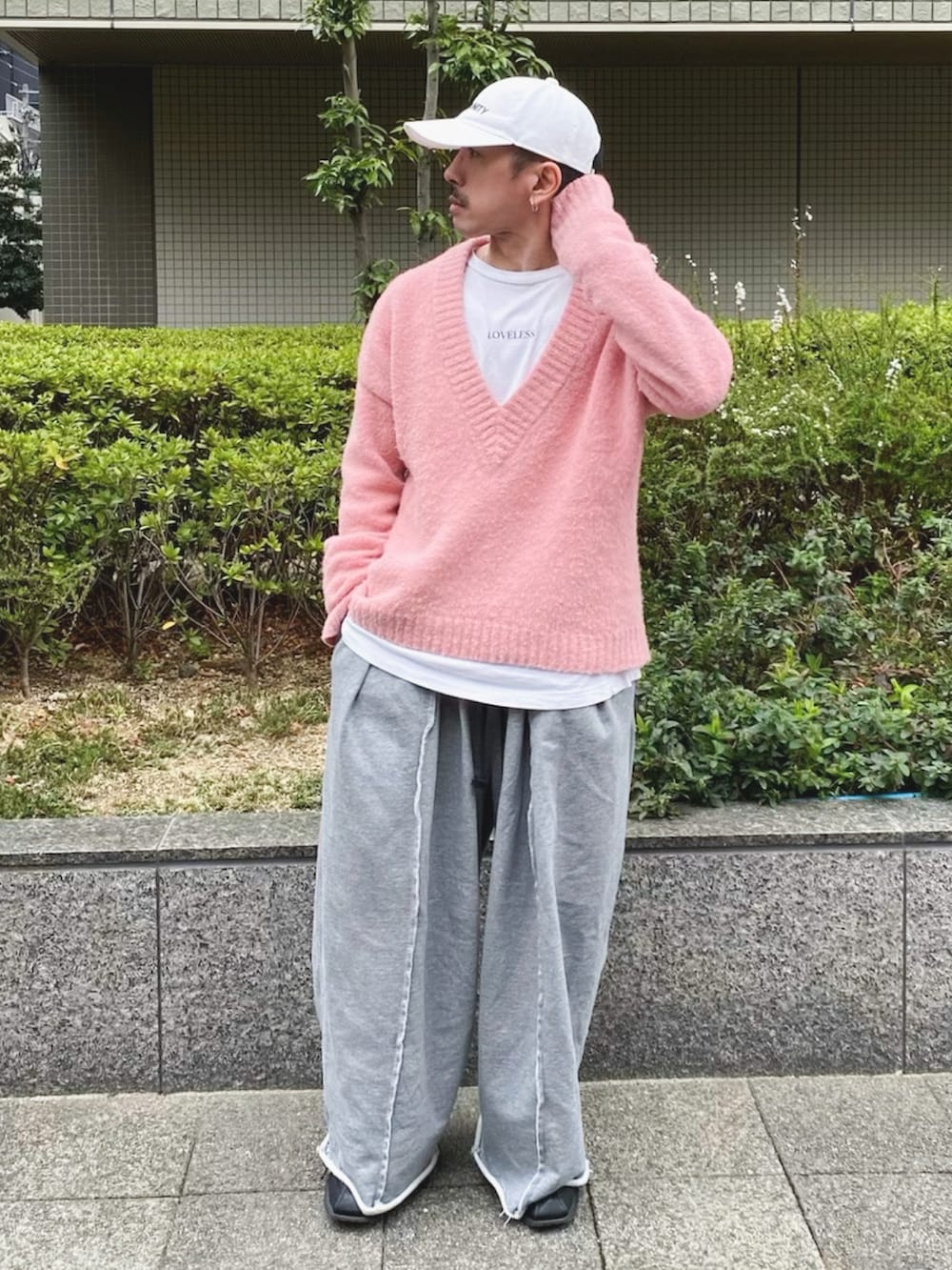 ピンク系のニット/セーター、グレー系のスウェットパンツ、ブラック系のスニーカーを着用したメンズの春コーディネートの3枚目の写真